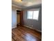 Bedroom features dark laminate floors, gray walls, a window, closet, and ceiling fan at 542 Sugar Hill Nw Dr, Marietta, GA 30060