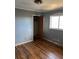 Bedroom features dark laminate floors, gray walls, a window, closet, and ceiling fan at 542 Sugar Hill Nw Dr, Marietta, GA 30060