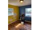 Bedroom with hardwood floors and bright yellow and blue walls needing repair at 542 Sugar Hill Nw Dr, Marietta, GA 30060