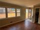 Bright living room featuring hardwood floors, three windows, and a view to the exterior of the home at 542 Sugar Hill Nw Dr, Marietta, GA 30060