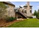 A backyard featuring artificial turf, stairs, and lush landscaping around the house's brick exterior at 225 Dovecrest Dr, Atlanta, GA 30305