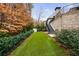 Backyard with artificial turf surrounded by lush landscaping and a set of stairs at 225 Dovecrest Dr, Atlanta, GA 30305