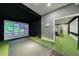 Indoor golf simulator room with putting green and projector screen for immersive play at 225 Dovecrest Dr, Atlanta, GA 30305