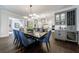 Modern eat-in kitchen with gray cabinets, wine rack, beverage refrigerator, and designer lighting at 225 Dovecrest Dr, Atlanta, GA 30305