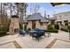 Gorgeous brick patio with outdoor furniture, a fireplace, and lush landscaping, creating a serene retreat at 225 Dovecrest Dr, Atlanta, GA 30305