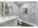 Stylish powder room featuring geometric wallpaper, dark wood flooring, and a decorative silver mirror at 225 Dovecrest Dr, Atlanta, GA 30305