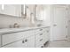 Bright bathroom features double sinks, chrome hardware, and medicine cabinet with lighting at 2828 Peachtree Nw Rd # 1002, Atlanta, GA 30305