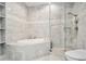 Luxurious bathroom with marble tile, soaking tub, and separate glass shower at 2828 Peachtree Nw Rd # 1002, Atlanta, GA 30305