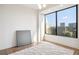 This bedroom features a large window with a city view and stylish area rug at 2828 Peachtree Nw Rd # 1002, Atlanta, GA 30305