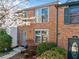 Brick-front townhome with charming curb appeal showcasing a decorative door wreath and blossoming spring foliage at 288 Roswell Commons Cir, Roswell, GA 30076