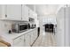 Well-lit kitchen featuring white cabinets and appliances, with a view of the dining area at 403 Keys Ferry Rd, Mcdonough, GA 30252