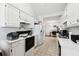 Bright kitchen with white cabinets and appliances, leading to a cozy dining area at 403 Keys Ferry Rd, Mcdonough, GA 30252