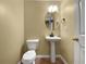 A half-bathroom features a pedestal sink with an oval mirror, a toilet, and red-toned tile flooring at 439 Emerald Trce, Jonesboro, GA 30236