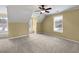 An empty bedroom has neutral-toned walls, carpet flooring, windows with blinds, and a ceiling fan at 439 Emerald Trce, Jonesboro, GA 30236