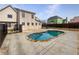 A kidney-shaped pool is surrounded by a concrete patio and black metal fence in the backyard at 439 Emerald Trce, Jonesboro, GA 30236