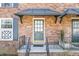 Close-up of the front door featuring a covered entryway, classic design, and brick facade at 5629 Kingsport Dr # 11, Atlanta, GA 30342