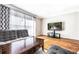 Relaxing living room featuring hardwood floors, grey sofa, curtains, and a modern television at 5629 Kingsport Dr # 11, Atlanta, GA 30342