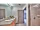 Bathroom featuring a light wood vanity, granite countertop, and a tiled shower with a glass door at 860 Peachtree Ne St # 917, Atlanta, GA 30308