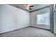 A bedroom with an exposed concrete ceiling, gray carpeting, and large windows at 860 Peachtree Ne St # 917, Atlanta, GA 30308