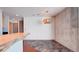 Dining room with modern light fixture and accent wall with stone tile leading to the kitchen at 860 Peachtree Ne St # 917, Atlanta, GA 30308