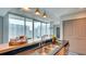 Modern kitchen with a breakfast bar, stainless steel sink, and a wall of windows with city views at 860 Peachtree Ne St # 917, Atlanta, GA 30308