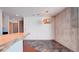 View of living room with slate-tiled area, partial kitchen island, and modern light fixture at 860 Peachtree Ne St # 917, Atlanta, GA 30308