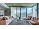 Open concept living area with stylish seating, a modern rug and expansive windows offering city views at 860 Peachtree Ne St # 917, Atlanta, GA 30308