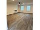Spacious living room with wood floors, ceiling fan, and natural light from two windows at 903 Jackson Oak Place, Villa Rica, GA 30180