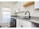 Bright laundry room features a modern washer and dryer, gray countertops, and white cabinets for ample storage at 1589 Mims Sw St, Atlanta, GA 30314