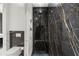 Modern bathroom features a glass-enclosed shower with rainfall shower head and black marble accent wall at 2828 Peachtree Nw Rd # 701, Atlanta, GA 30305