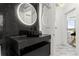 Modern bathroom features a marble wall, vessel sink, and a round, lighted mirror at 2828 Peachtree Nw Rd # 701, Atlanta, GA 30305