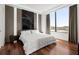Bedroom features a queen bed, hardwood floors, accent wall, and large windows with curtains at 2828 Peachtree Nw Rd # 701, Atlanta, GA 30305
