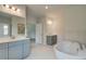 Bright bathroom featuring dual vanities, soaking tub, and separate shower at 31 Homesite Cooper E Cv, Fayetteville, GA 30214