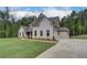 Well-manicured lawn of a home with an attached two-car garage and long driveway, showing classic design at 31 Homesite Cooper E Cv, Fayetteville, GA 30214