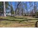 Expansive backyard featuring a blend of lush grass and mature trees offering shade and privacy at 3594 Vinyard Way, Lawrenceville, GA 30044