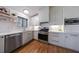 Well-lit kitchen with white cabinets, stainless steel appliances and wood flooring at 3594 Vinyard Way, Lawrenceville, GA 30044