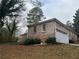 Brick home with a garage, surrounded by greenery, offering a blend of comfort and practicality at 676 Bralorne Dr, Stone Mountain, GA 30087
