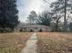 Inviting brick home with a pathway, surrounded by lush trees, offering a classic and welcoming curb appeal at 676 Bralorne Dr, Stone Mountain, GA 30087