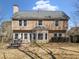 Back exterior view of a well-maintained two-story house with a patio and lawn at 7104 Big Woods Dr, Woodstock, GA 30189
