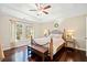 Inviting bedroom with tray ceiling, hardwood floors, and large windows at 7104 Big Woods Dr, Woodstock, GA 30189