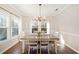 Elegant dining room with a chandelier, wood floors, and natural light from the windows at 7104 Big Woods Dr, Woodstock, GA 30189