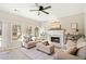 Bright living room with fireplace, ceiling fan, and lots of natural light from the many windows at 7104 Big Woods Dr, Woodstock, GA 30189