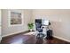 Hardwood office with an adjustable desk and green plant at 7104 Big Woods Dr, Woodstock, GA 30189