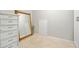 Neutral room with beige stone floor, large mirror and white cabinets at 7104 Big Woods Dr, Woodstock, GA 30189