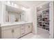Bathroom featuring double sink vanity, framed mirror and walk-in closet with built in shelves at 1053 Knoxboro Ln, Woodstock, GA 30188