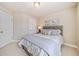 Cozy bedroom with a grey tufted headboard and large sunny window at 1053 Knoxboro Ln, Woodstock, GA 30188