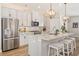 Spacious kitchen with island, breakfast bar, stainless steel appliances, and white cabinetry at 1053 Knoxboro Ln, Woodstock, GA 30188