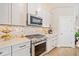 Modern kitchen with stainless steel appliances, herringbone backsplash and bright white cabinets at 1053 Knoxboro Ln, Woodstock, GA 30188