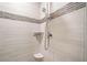 Bright shower featuring modern tile, overhead shower head, and built-in shelving niche at 1053 Knoxboro Ln, Woodstock, GA 30188