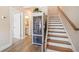 Inviting foyer with hardwood floors, staircase, and decorative cabinet with glass doors at 1053 Knoxboro Ln, Woodstock, GA 30188